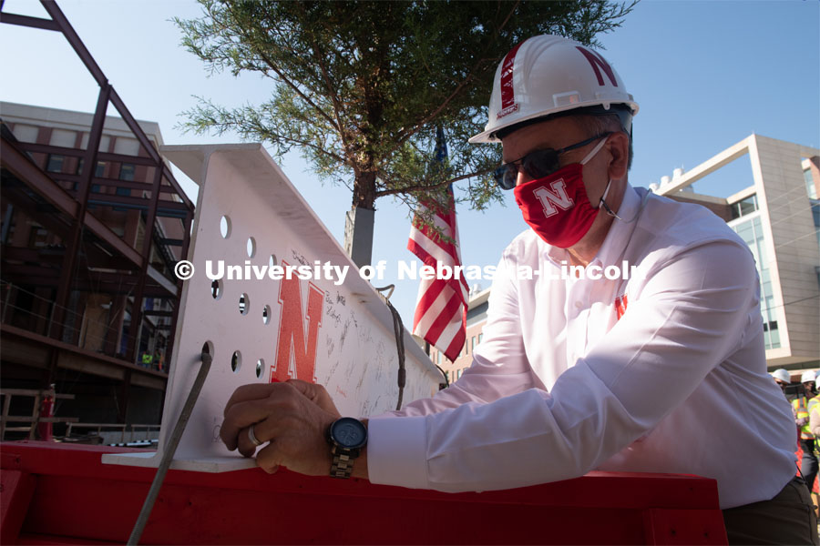 Chancellor Ronnie Green adds signatures to the last beam before it is placed. Due to COVID-19 precautions, a public ceremony was not able to be held. Instead, signatures from college and university supporters and others involved in the Phase I project were gathered either remotely or by signing the beam individually. The final beam was installed at the topping off ceremony for Engineering Project, August 26, 2020. Photo by Greg Nathan / University Communication.